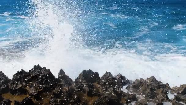 Morska burza 4k koncepcja, materiał krajobrazowy oceanu błękitnej wody i skał, słoneczny dzienny krajobraz morski, niszczące i spektakularne, fale oceaniczne rozbijają się na skałach wybrzeża tworząc eksplozję wody — Wideo stockowe