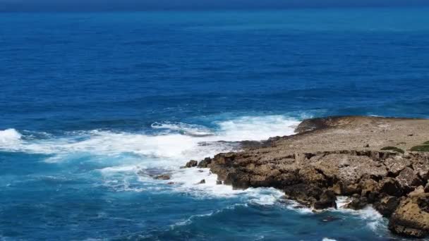 Imagens da paisagem de água azul do mar e rochas, paisagem ensolarada diurna, Devastante e espetacular, ondas do oceano bater sobre as rochas da costa, criando uma explosão de água — Vídeo de Stock