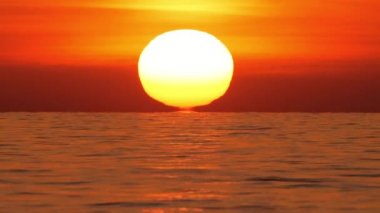 Sıcak Hava Bozukluğu 'nda Big Red Hot Sun, Okyanus Ufku' nun Üzerinde, Denizin Üzerinde Günbatımı, Bulutlu Büyük Doğan Güneş. Yakın plan Telefoto Lensleri. Seyahat, Başlangıç, Doğa Konsepti