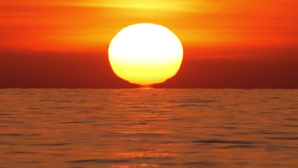 オーシャンホライズン、海の上の暖かい空気の歪みで大きな赤い熱い太陽、海の上の日没、雲と大きな上昇日。望遠レンズを閉じる。旅、始まり、自然概念 — ストック動画