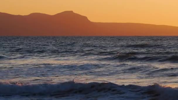 Paisaje marino dramático natural, amanecer con montañas, sol del atardecer que brilla a través de las olas doradas, océano y mar cámara lenta 4k — Vídeos de Stock