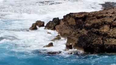 Mavi deniz suyunun ortasında büyük taşlar, okyanus mavi su ve kayaların 4k manzara görüntüleri, güneşli gündüz deniz manzarası, Kıbrıs