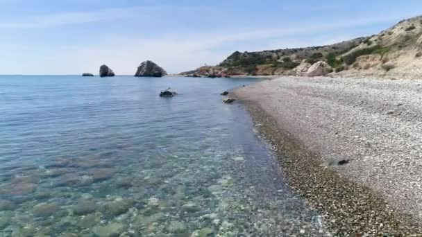 Vacker medelhavsstrand med småsten. Semester och koppla av i en avskild plats, Sommardag havsutsikt. Klar vattenstruktur. Ovanifrån i 4K — Stockvideo