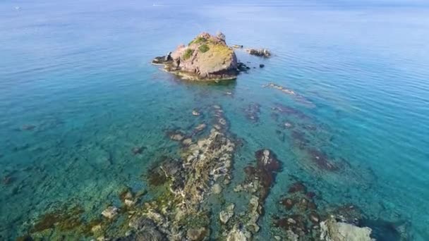 Um pico rochoso solitário no mar aberto, vista aérea superior. Ondas oceânicas na bela praia drone aéreo 4k tiro — Vídeo de Stock