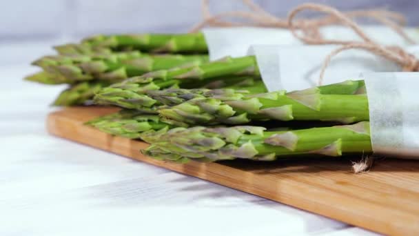 Espargos, verde orgânico cru fresco Espargos brotos closeup, comida vegetariana saudável. Legumes crus, mercado. Cenário vegano. câmera lenta 4K UHD de vídeo — Vídeo de Stock