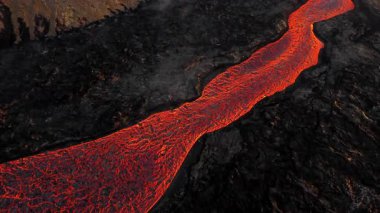 Litli-Hrutur volkanından fışkıran erimiş lav nehrinin üzerinden geçen hava aracı 2023 yılında karanlık kayaların içinden geçer. Turistlerin güzel ve tehlikeli felaketlere olan ilgisi. Yüksek kalite 4k görüntü