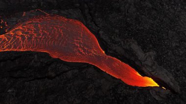 Litli-Hrutur volkanından fışkıran erimiş lav nehrinin üzerinden geçen hava aracı 2023 yılında karanlık kayaların içinden geçer. Turistlerin güzel ve tehlikeli felaketlere olan ilgisi. Yüksek kalite 4k görüntü