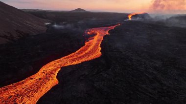 Litli-Hrutur volkanından fışkıran erimiş lav nehrinin üzerinden geçen hava aracı 2023 yılında karanlık kayaların içinden geçer. Turistlerin güzel ve tehlikeli felaketlere olan ilgisi. Yüksek kalite 4k görüntü