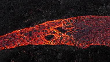 Litli-Hrutur volkanından fışkıran erimiş lav nehrinin üzerinden geçen hava aracı 2023 yılında karanlık kayaların içinden geçer. Turistlerin güzel ve tehlikeli felaketlere olan ilgisi. Yüksek kalite 4k görüntü