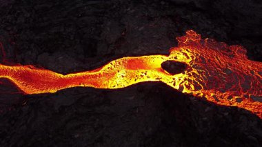 Litli-Hrutur volkanından fışkıran erimiş lav nehrinin üzerinden geçen hava aracı 2023 yılında karanlık kayaların içinden geçer. Turistlerin güzel ve tehlikeli felaketlere olan ilgisi. Yüksek kalite 4k görüntü