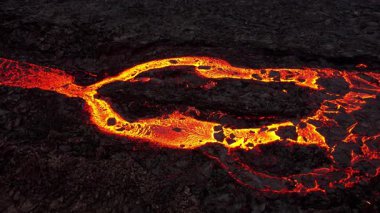 Litli-Hrutur volkanından fışkıran erimiş lav nehrinin üzerinden geçen hava aracı 2023 yılında karanlık kayaların içinden geçer. Turistlerin güzel ve tehlikeli felaketlere olan ilgisi. Yüksek kalite 4k görüntü