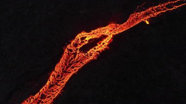 Litli-Hrutur volkanından fışkıran erimiş lav nehrinin üzerinden geçen hava aracı 2023 yılında karanlık kayaların içinden geçer. Turistlerin güzel ve tehlikeli felaketlere olan ilgisi. Yüksek kalite 4k görüntü