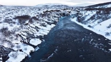 İzlanda 'da Nehir, Karlı Tepeler ve Kışın Şelaleler, Dev Akıntılı Büyülü Mavi Buzul Suyu. Hraunfossar. Yüksek kalite 4k görüntü