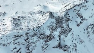 Dik tepeler buz ve karla kaplıdır ve vadiler bulutlar ve sisle örtülüdür. Yüksek kalite 4k görüntü