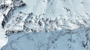 Dik tepeler buz ve karla kaplıdır ve vadiler bulutlar ve sisle örtülüdür. Yüksek kalite 4k görüntü