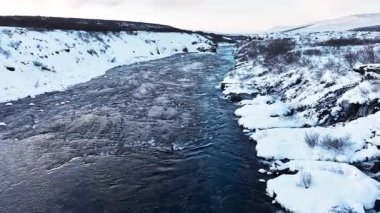 Saf turkuaz su, dev bir akıntısı olan buzul nehri İzlanda 'da şelale, kışın donmuş şelale, kar ve buzun büyülü kış mekanı, popüler turizm merkezi.