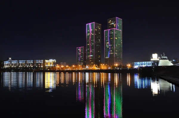 River Embankment . Illumination of modern buildings . Reflection in water. — Stock Photo, Image