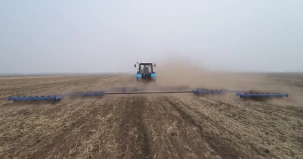 Sowing preparation. A tractor cultivates the soil in the field. — Stock Video