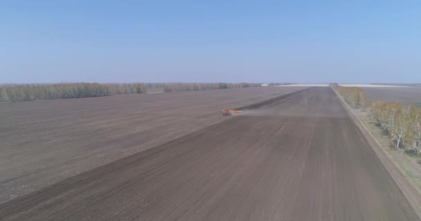 Výsev. Farmář na traktoru zasévá korunu na velkém poli. — Stock video