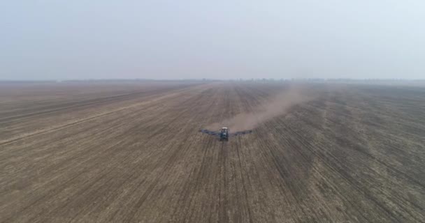 Préparation au semis. Un agriculteur sur un tracteur cultive le sol dans le grand champ. — Video