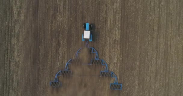 Zaaivoorbereiding. Een boer op een tractor verbouwt de grond in het veld. — Stockvideo