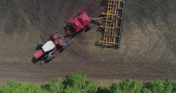 Vista aérea do trator trabalha no campo semeia e arado o solo ao mesmo tempo. — Vídeo de Stock