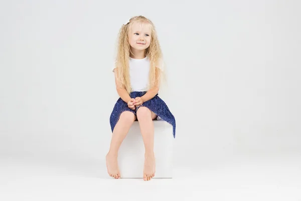 Cute little girl on cube — Stock Photo, Image