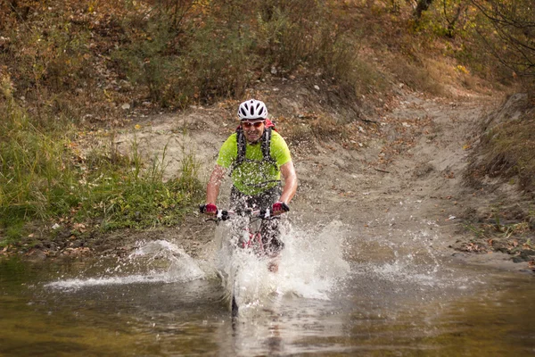 Ciclista pasa un río . — Foto de Stock