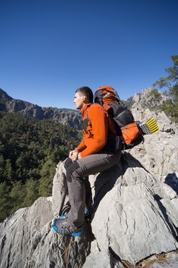 Güneşli bir günde dağlarda hiking bir sırt çantası olan bir adam.