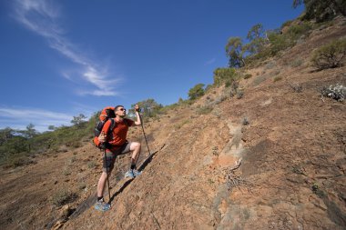 Güneşli bir günde dağlarda hiking bir sırt çantası olan bir adam.