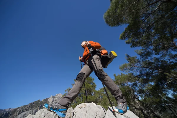 En man med en ryggsäck vandring i bergen på en solig dag. — Stockfoto