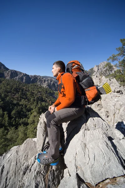 Güneşli bir günde dağlarda hiking bir sırt çantası olan bir adam.