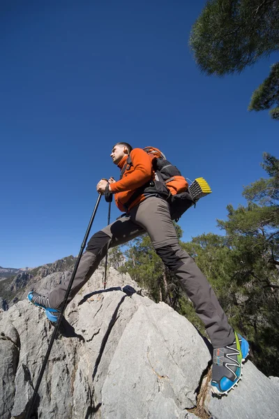 En man med en ryggsäck vandring i bergen på en solig dag. — Stockfoto
