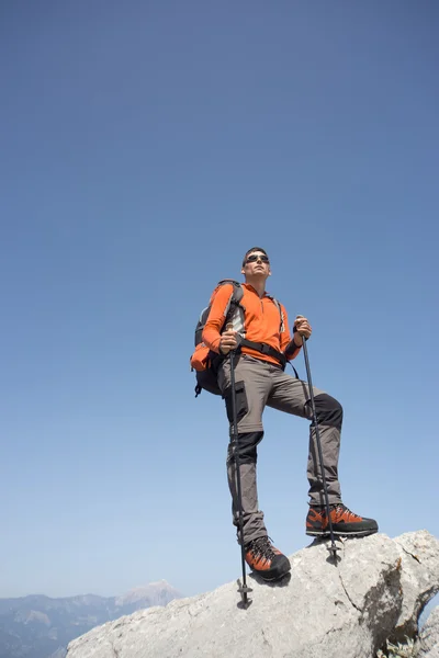 Ein Mann mit Rucksack wandert an einem sonnigen Tag in den Bergen. — Stockfoto