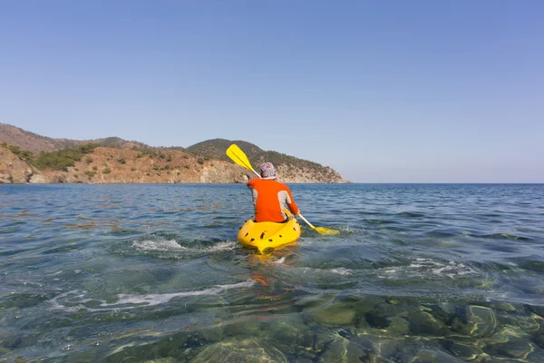 Un homme voyageant en canot le long de la côte en été . — Photo