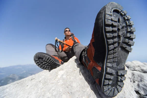 Un hombre con una mochila caminando en las montañas en un día soleado . — Foto de Stock