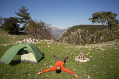 Güneşli bir yaz aylarında dağlarda çadır kamp adam.