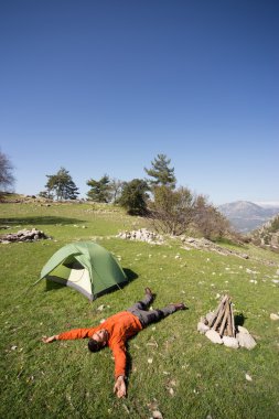Güneşli bir yaz aylarında dağlarda çadır kamp adam.
