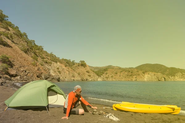 L'uomo sulla spiaggia con kayak e tenda in una giornata di sole . — Foto Stock