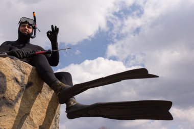 Bir avcı bir sualtı tüplü silahla adam kılığında.