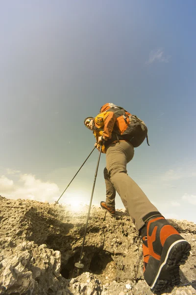 Junger Mann mit Rucksack auf einem Berggipfel an einem sonnigen Tag. — Stockfoto