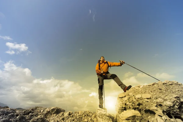 Jeune homme avec sac à dos sur un sommet de montagne par une journée ensoleillée . — Photo