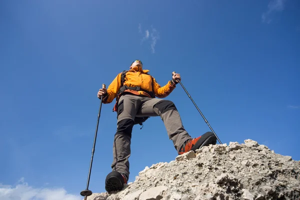 Молодий чоловік з рюкзаком на вершині гори в сонячний день . — стокове фото