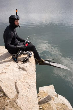 Bir avcı bir sualtı tüplü silahla adam kılığında.