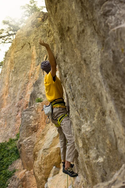 Joven escalador colgado en un acantilado con una cuerda . — Foto de Stock