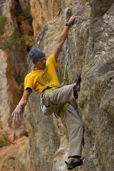 Joven escalador colgado en un acantilado con una cuerda . — Foto de Stock