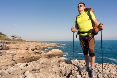 Güneşli bir günde dağlarda hiking bir sırt çantası olan bir adam.