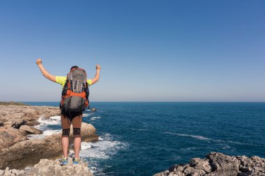 Güneşli bir günde dağlarda hiking bir sırt çantası olan bir adam.
