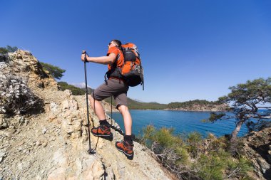 Güneşli bir günde dağlarda hiking bir sırt çantası olan bir adam.