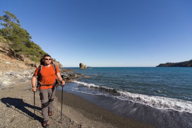 Güneşli bir günde dağlarda hiking bir sırt çantası olan bir adam.